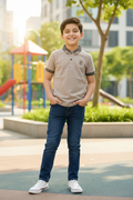 Boy 8-9 years in light brown polo shirt standing
