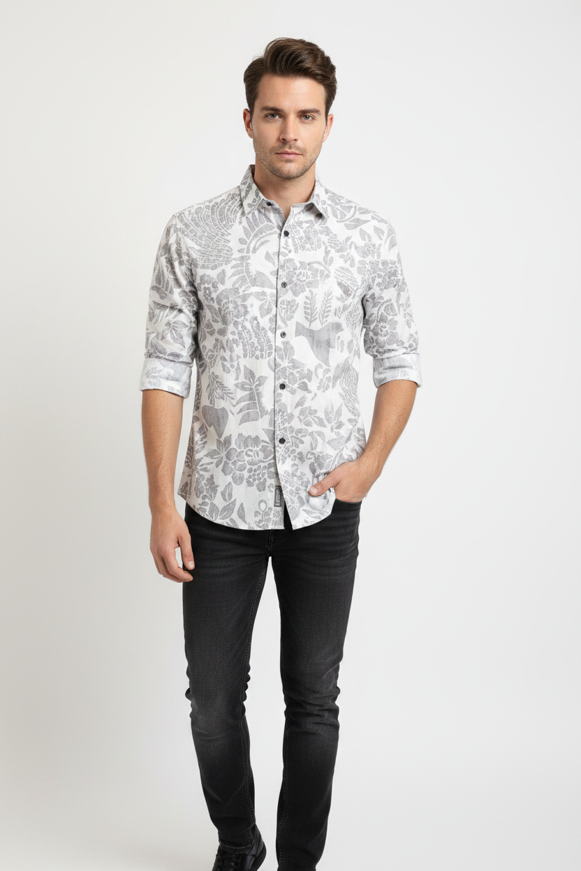 Male model wearing grey floral print shirt with sleeves rolled halfway, untucked with jeans