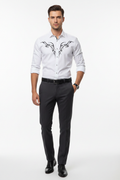 Male model wearing white abstract pattern shirt untucked with dark trousers