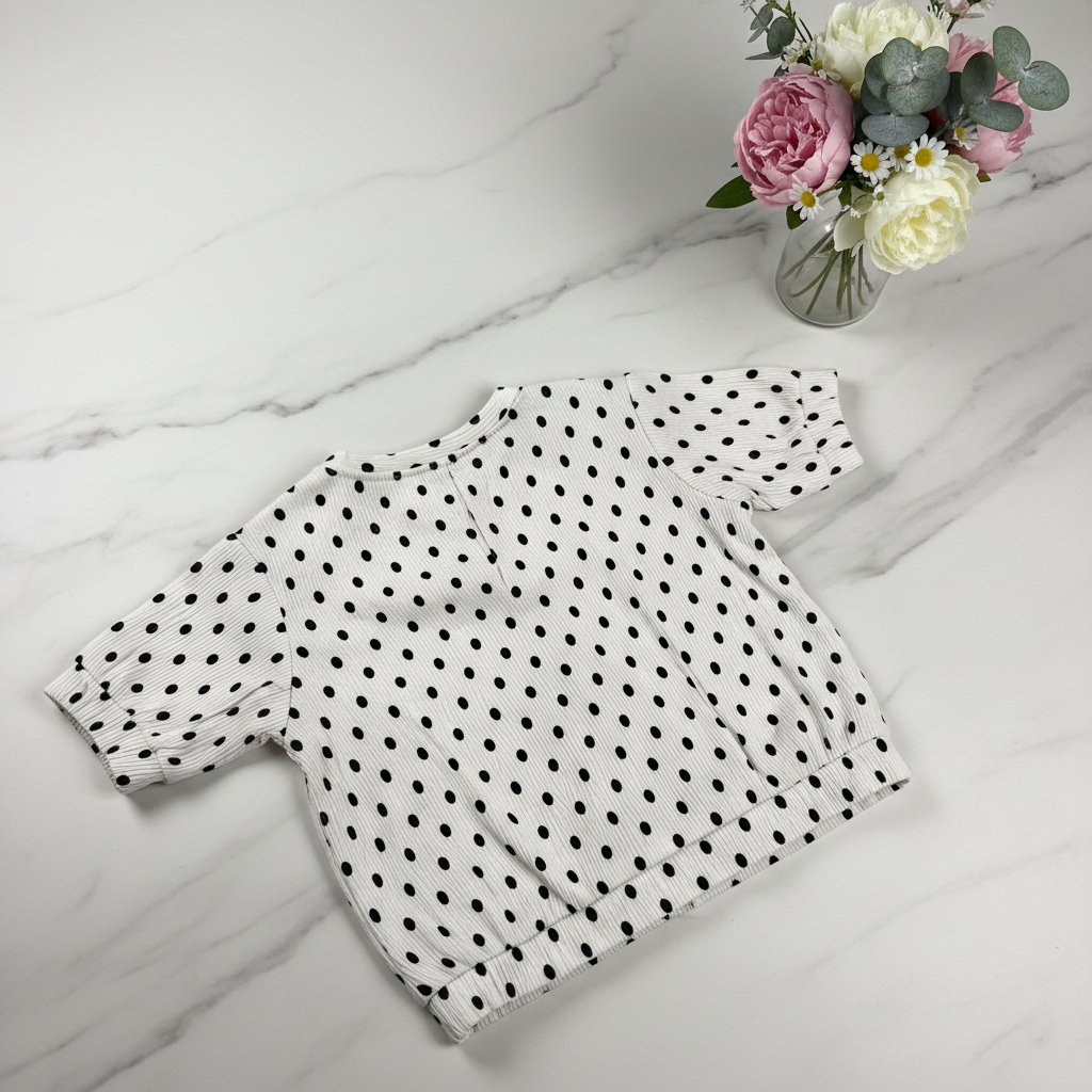 White polka dot top back view - marble surface